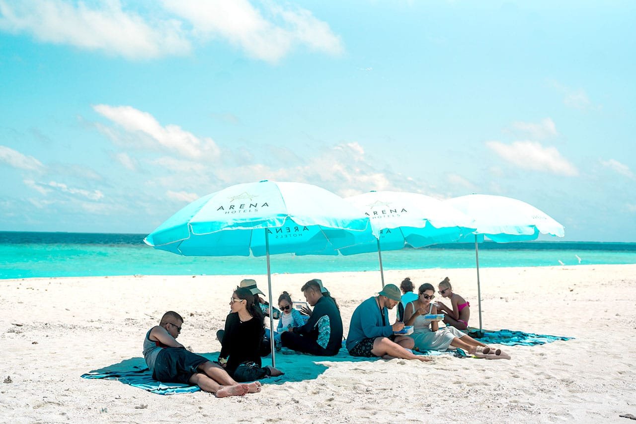 Guests relaxing under Arena beach umbrellas
