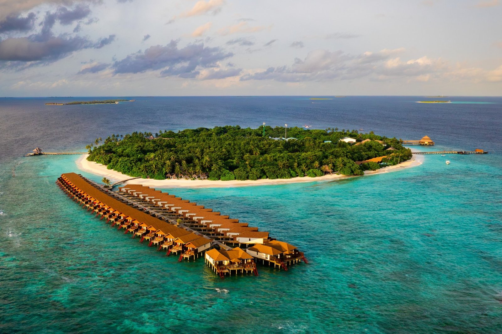 Aerial view of Reethi Faru Resort island with the water villa jetty