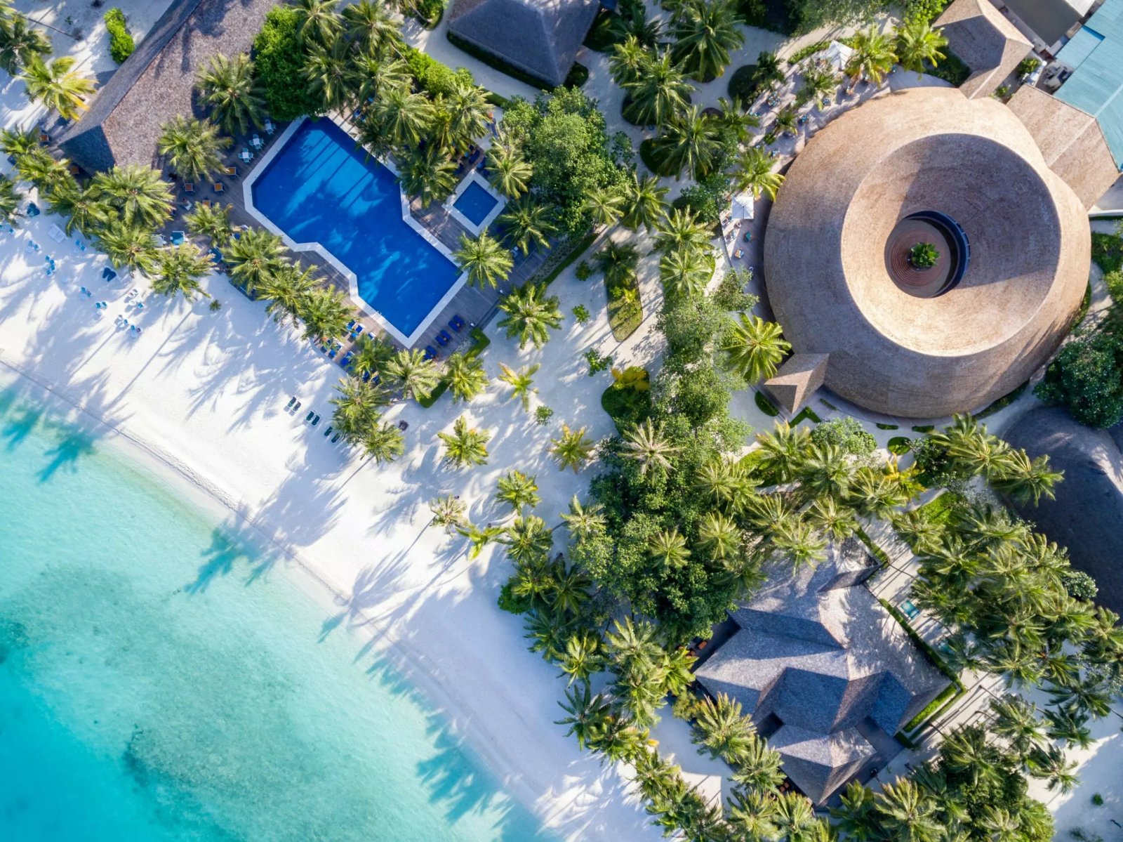 Aerial view of the beach and a villa pool