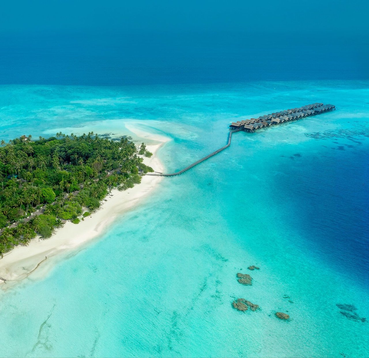 Aerial view of a white-sand spit and jetty