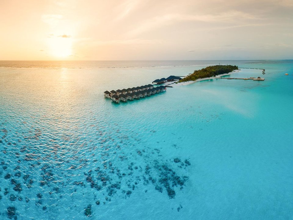 Aerial view of the overwater villas at sunset