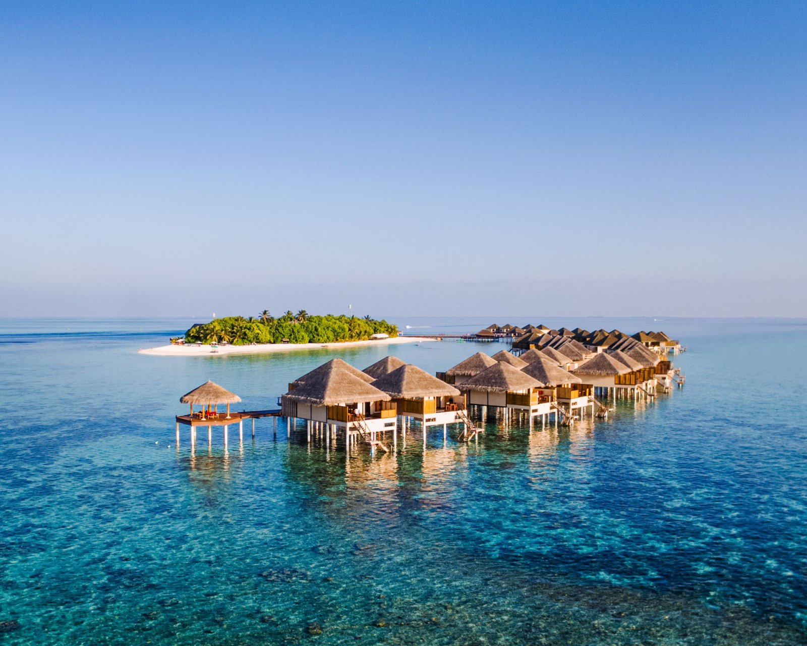 Overwater villas on the reef beside the island